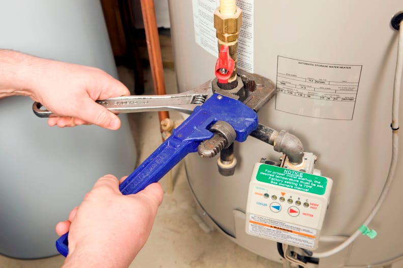 Plumber repairing a water heater valve in Haverford